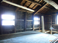 Before2 ／倉内部：土壁の裏返しがなく竹子舞が露出している状態。写真は母屋側に小窓を開けているところ。